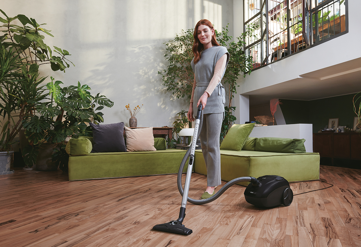 Μία γυναίκα σκουπίζει το σαλόνι